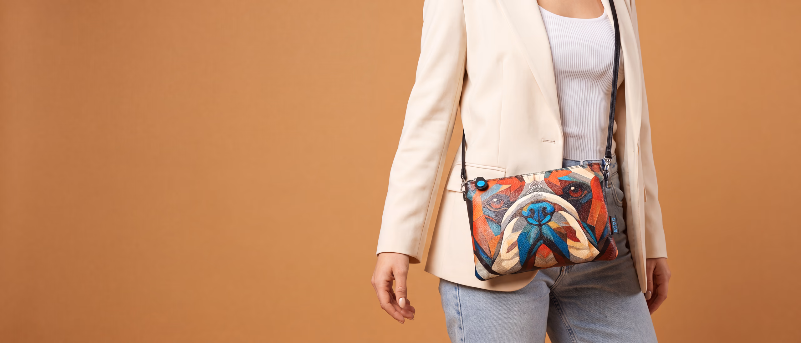 A printed leather crossbody bag worn over the shoulder